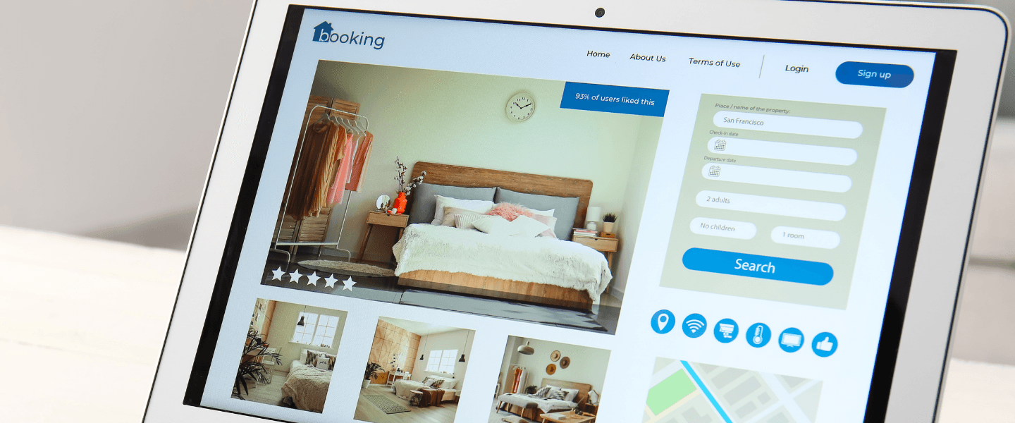Tablet mit geöffneter Buchungsplattform, die ein Hotelzimmer mit Bildern, Beschreibung und Chat-Funktion zur Reiseplanung zeigt.