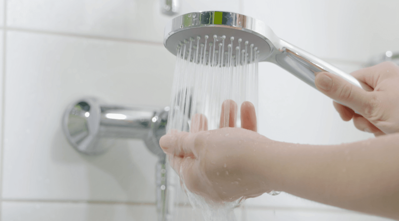 Offene Hand unter einem kräftigen Wasserstrahl
