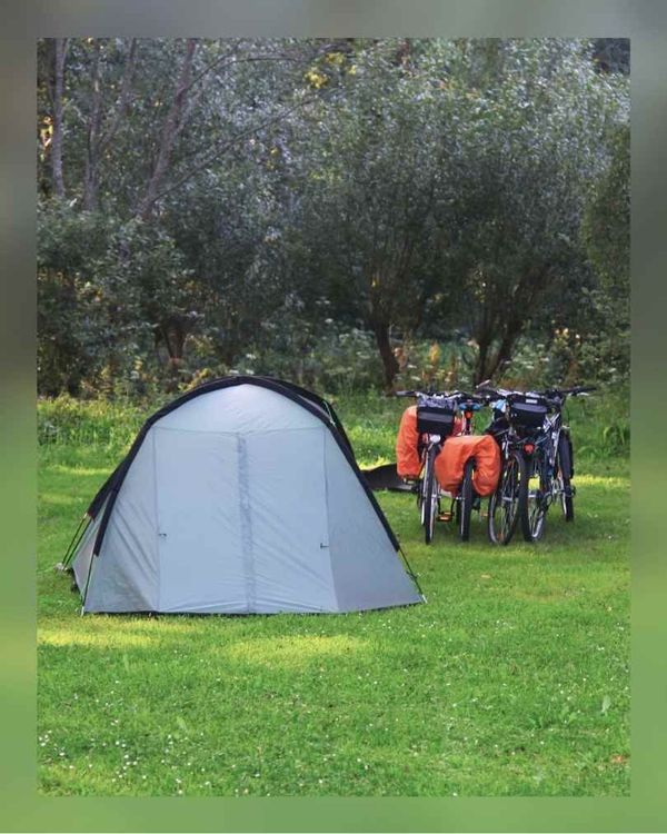 Zelt mit Rädern mit Packtaschen auf einer Wiese