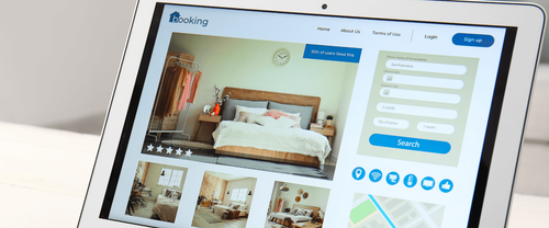 Tablet mit geöffneter Buchungsplattform, die ein Hotelzimmer mit Bildern, Beschreibung und Chat-Funktion zur Reiseplanung zeigt.